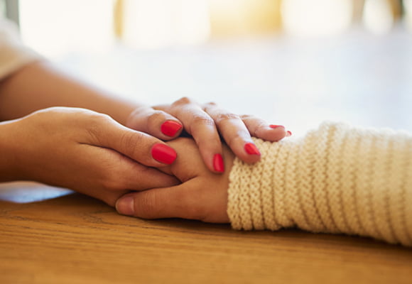 Two hands of one person holding another persons hand.